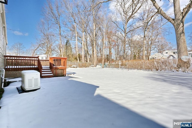 yard layered in snow featuring a deck