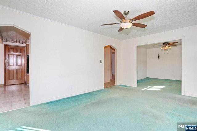 spare room featuring crown molding, light carpet, and ceiling fan