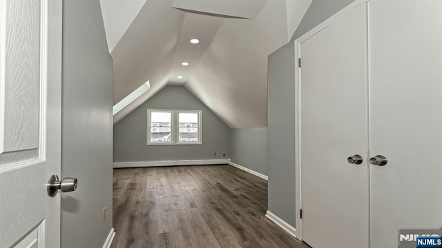 bonus room with vaulted ceiling, a baseboard heating unit, and dark hardwood / wood-style floors