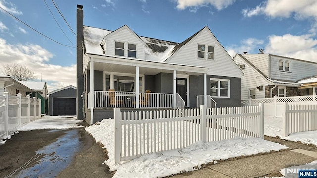 view of front of home featuring an outbuilding, a garage, and covered porch