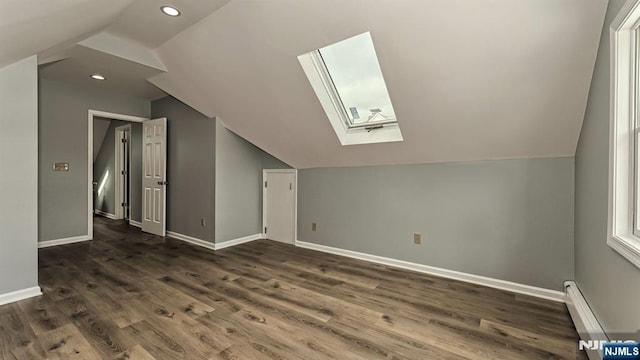 bonus room featuring a baseboard radiator, dark hardwood / wood-style floors, and vaulted ceiling with skylight