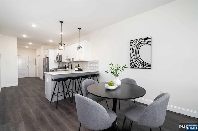 dining area with dark hardwood / wood-style floors and sink