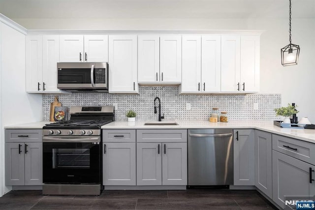 kitchen with appliances with stainless steel finishes, gray cabinets, sink, and white cabinets