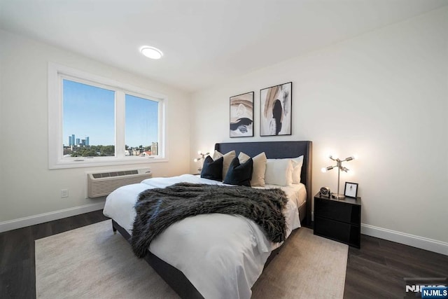 bedroom with dark hardwood / wood-style floors and a wall mounted AC