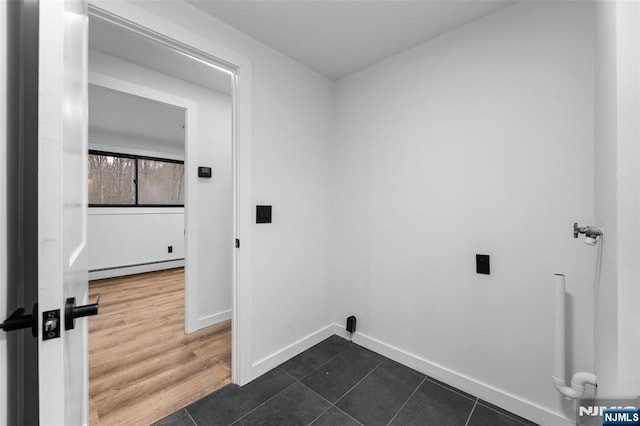 clothes washing area featuring a baseboard heating unit and dark wood-type flooring