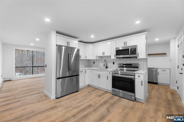 kitchen with white cabinetry, appliances with stainless steel finishes, sink, and backsplash