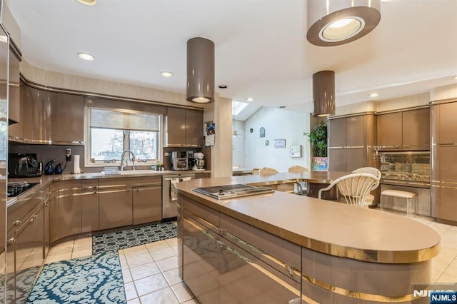 kitchen with appliances with stainless steel finishes, sink, and light tile patterned floors