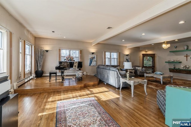 living room with a baseboard heating unit, beam ceiling, and hardwood / wood-style floors