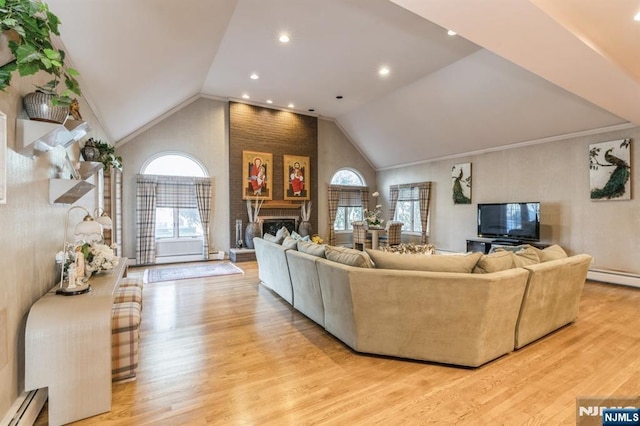 living room featuring vaulted ceiling, light wood-type flooring, a fireplace, and baseboard heating