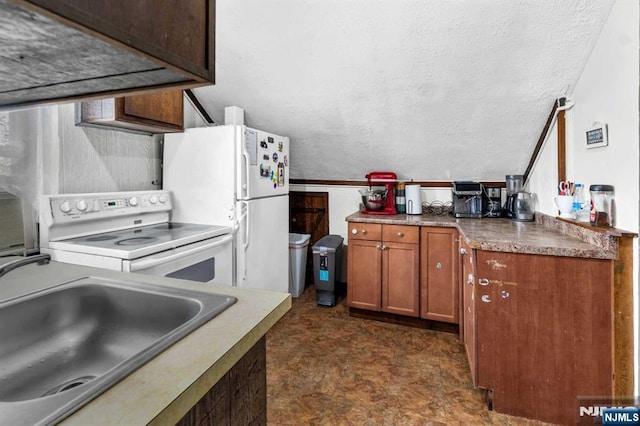 kitchen with vaulted ceiling, white appliances, sink, and a textured ceiling