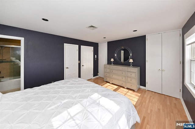 bedroom featuring two closets and light wood-type flooring