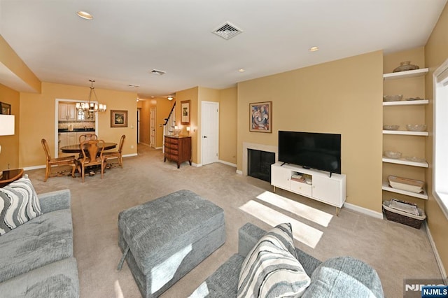 living room featuring light colored carpet and an inviting chandelier