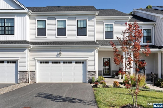 townhome / multi-family property featuring a garage and a front lawn