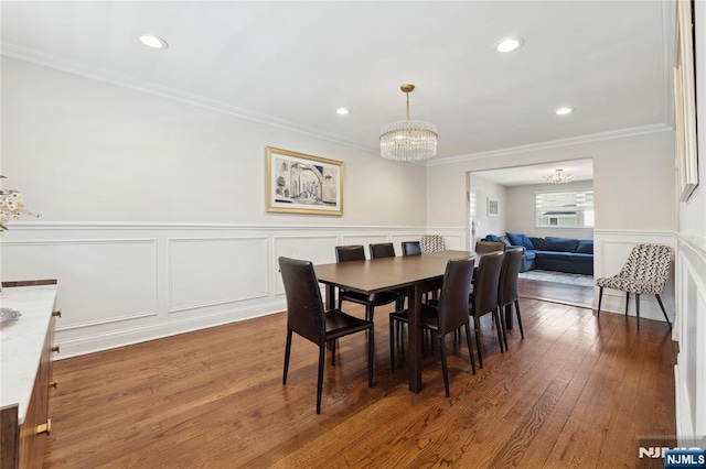 dining area featuring crown molding, a chandelier, and dark wood-type flooring