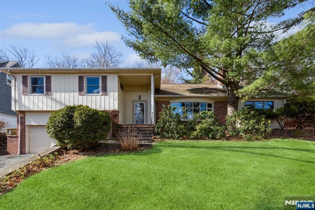 view of front of house featuring a garage and a front lawn