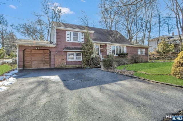 tri-level home featuring a garage and a front lawn