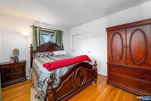 bedroom featuring light wood finished floors, a closet, and baseboards