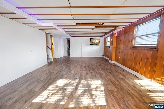 interior space featuring stairway, wood walls, wood finished floors, and baseboards