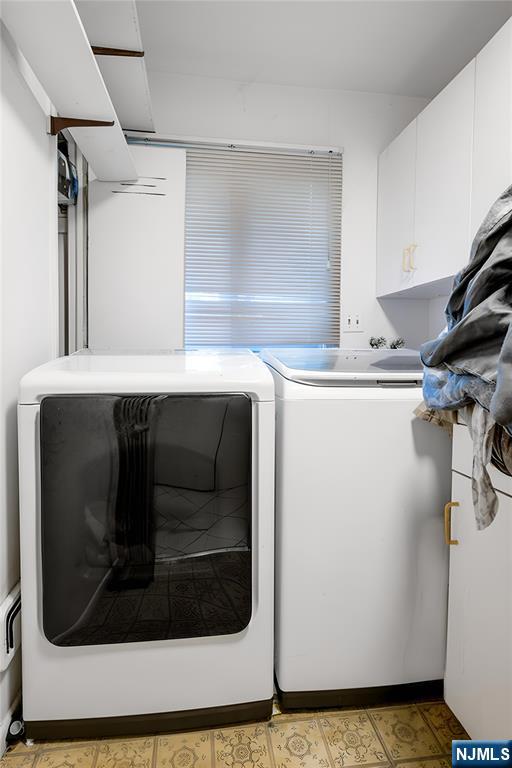 laundry area with washing machine and dryer and cabinet space