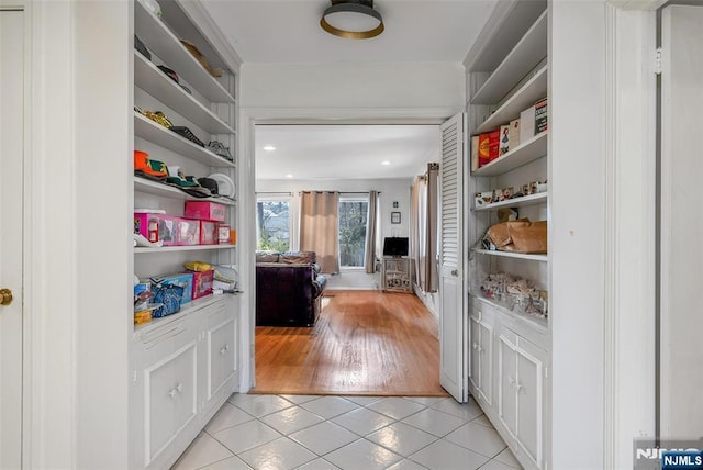 hallway featuring light tile patterned floors and built in shelves