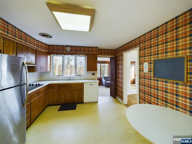 kitchen with dishwasher, sink, stainless steel fridge, and black electric cooktop