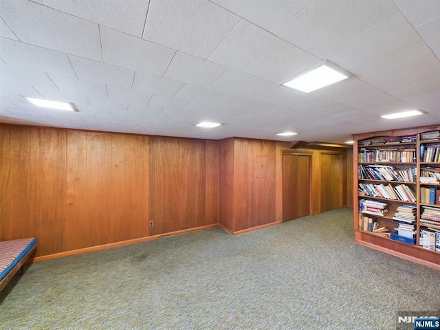 basement featuring carpet flooring and wooden walls