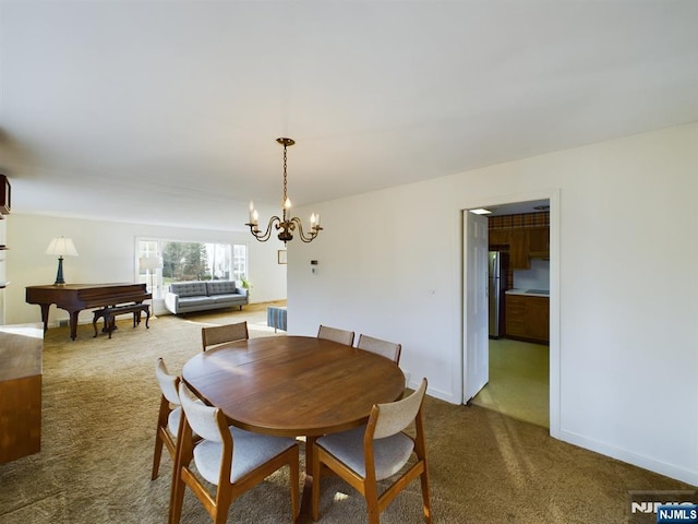 carpeted dining area featuring an inviting chandelier