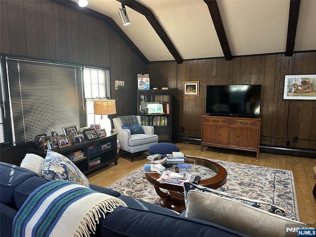 living area featuring vaulted ceiling with beams, wooden walls, and wood finished floors