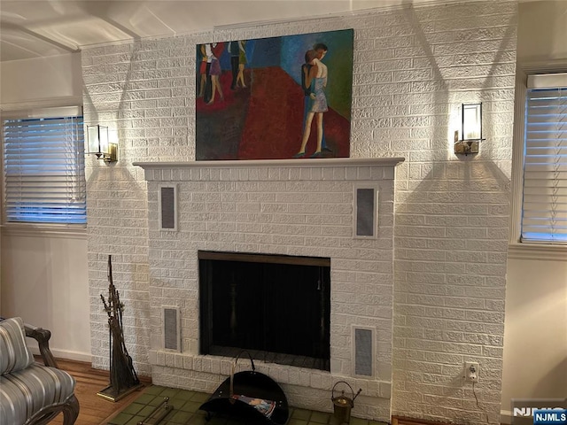 unfurnished living room featuring a fireplace, wood finished floors, and visible vents