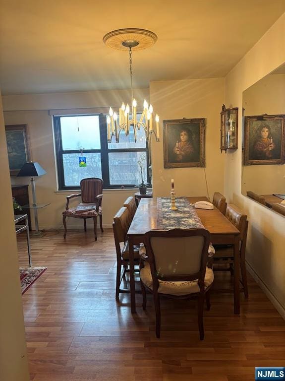 dining area featuring wood-type flooring and a chandelier