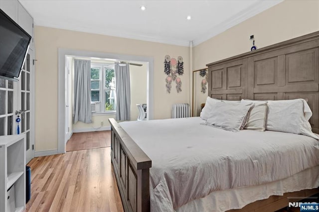 bedroom featuring radiator, crown molding, and light hardwood / wood-style flooring