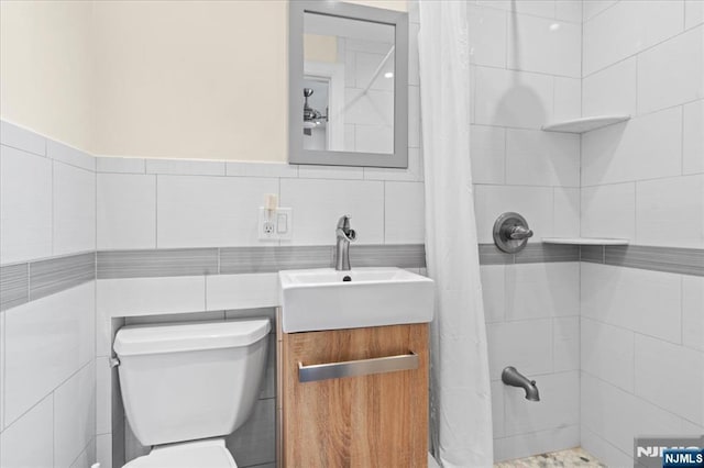 bathroom with tile walls, vanity, a shower with curtain, and toilet