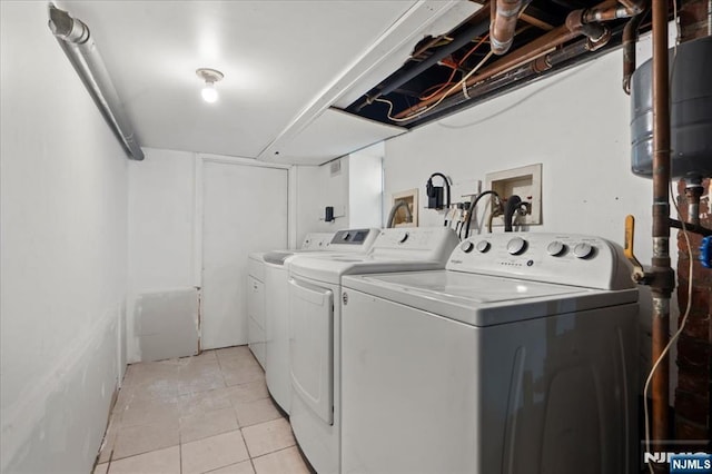 laundry area featuring light tile patterned flooring and washing machine and clothes dryer