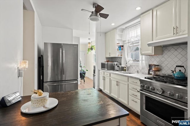 kitchen with sink, white cabinetry, ceiling fan, stainless steel appliances, and decorative backsplash