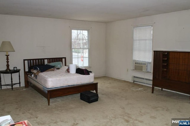 carpeted bedroom with a baseboard heating unit and cooling unit