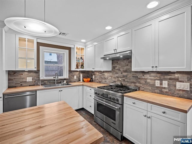 kitchen with white cabinetry, appliances with stainless steel finishes, and wooden counters