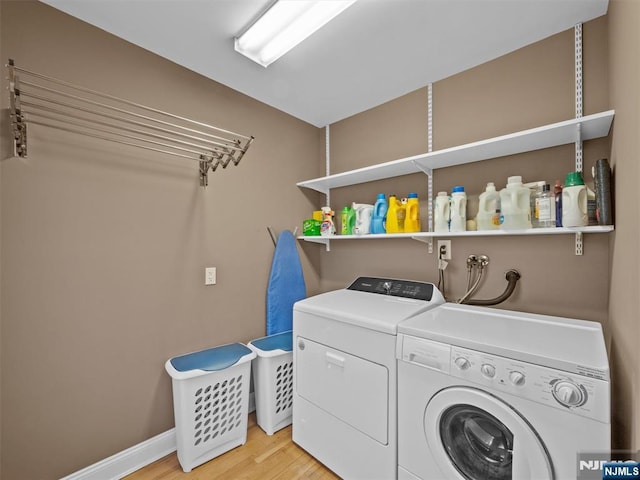 laundry area with washing machine and dryer and light hardwood / wood-style floors