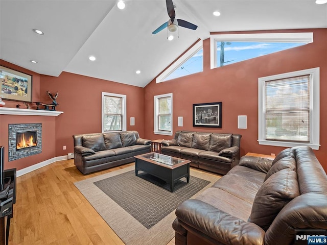 living room featuring baseboard heating, ceiling fan, high vaulted ceiling, and light hardwood / wood-style flooring