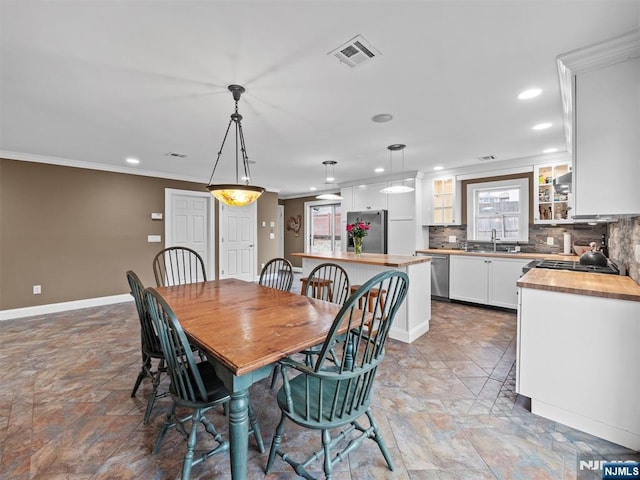 dining space featuring sink and crown molding