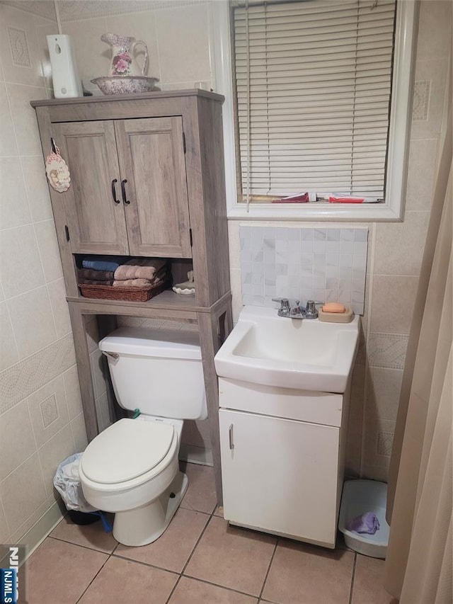 bathroom featuring tile walls, vanity, tile patterned floors, and toilet