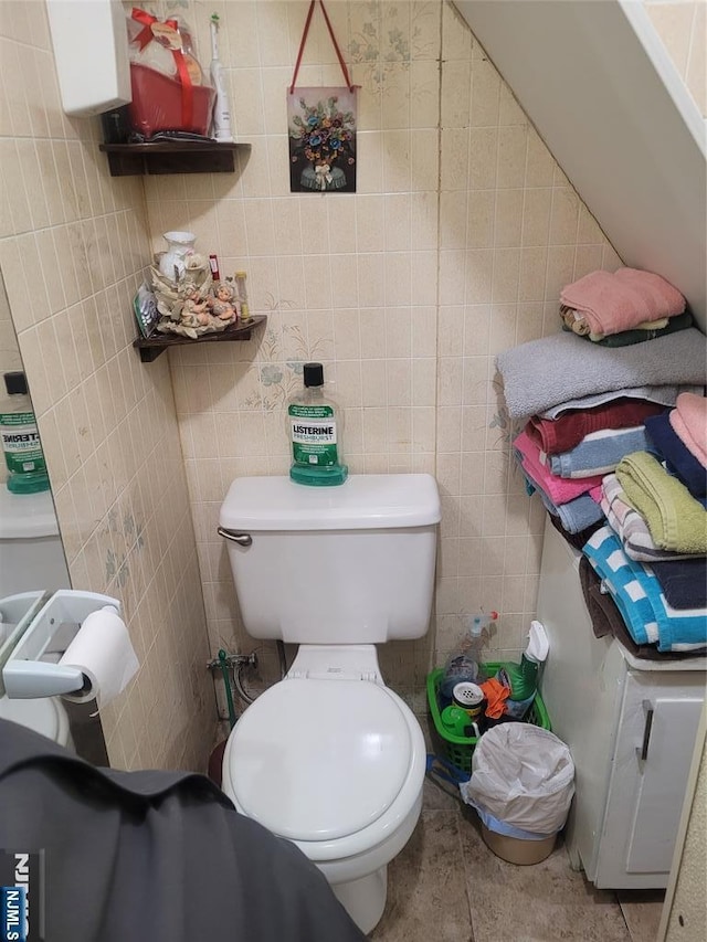 bathroom featuring tile walls and toilet