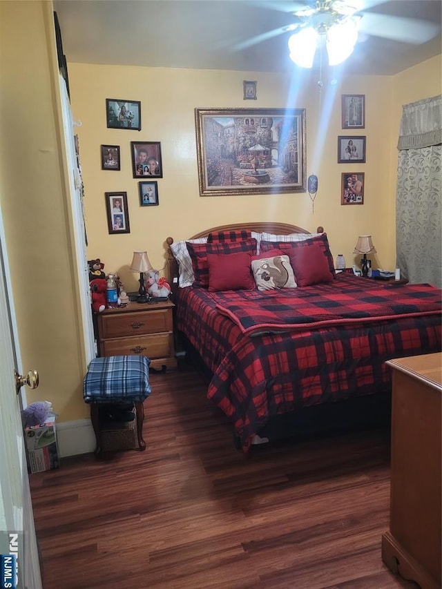 bedroom with dark hardwood / wood-style floors and ceiling fan