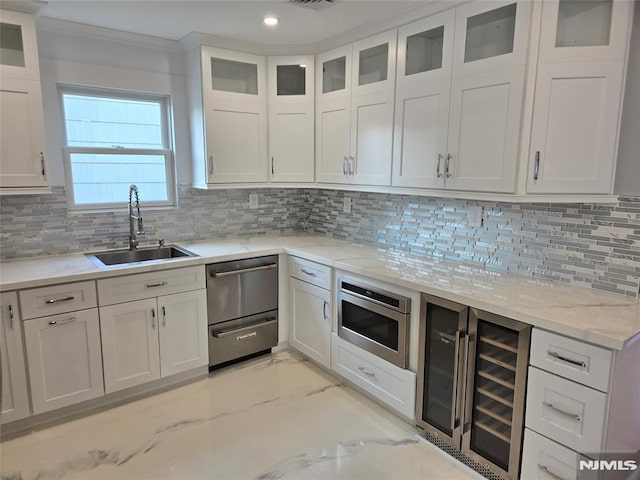 kitchen featuring sink, stainless steel microwave, white cabinets, and beverage cooler