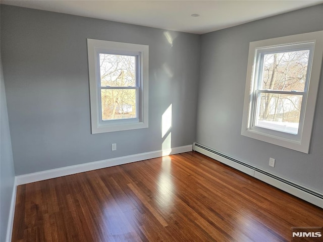 empty room with a baseboard radiator and wood-type flooring