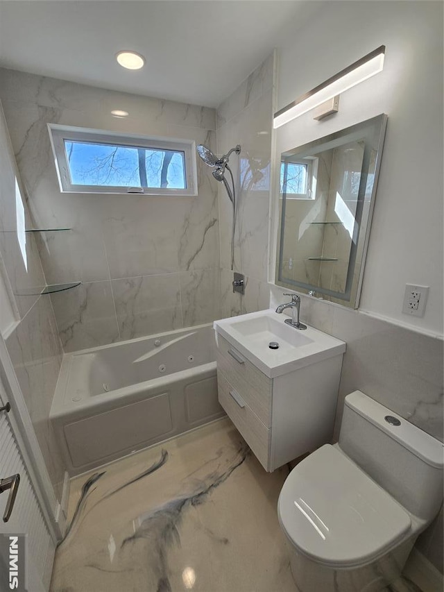 full bathroom featuring tiled shower / bath combo, vanity, and toilet