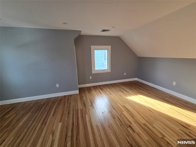 bonus room with lofted ceiling and wood-type flooring