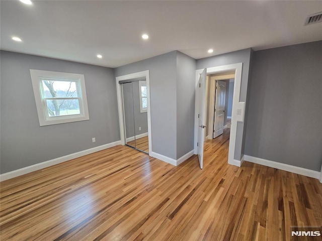 unfurnished bedroom featuring a closet and light wood-type flooring