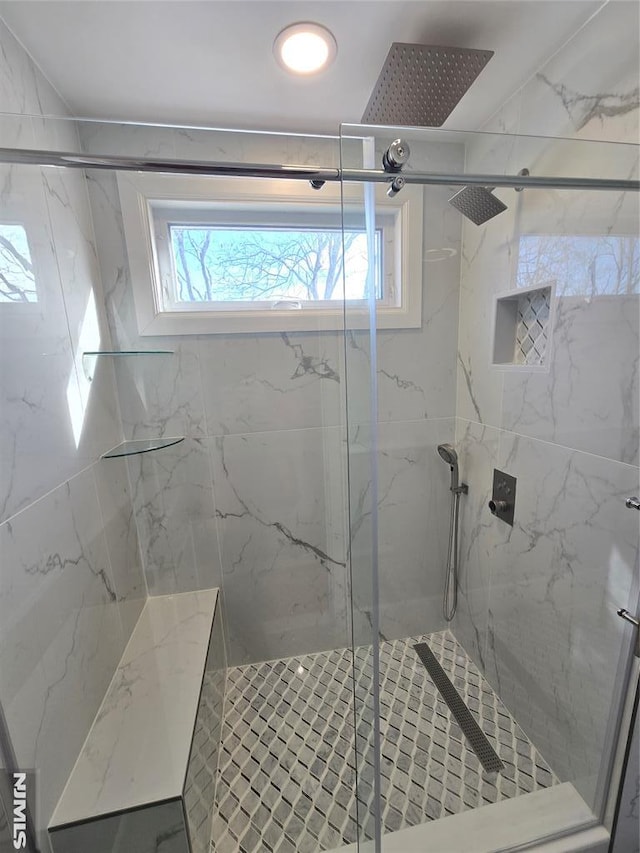 bathroom with a shower with door