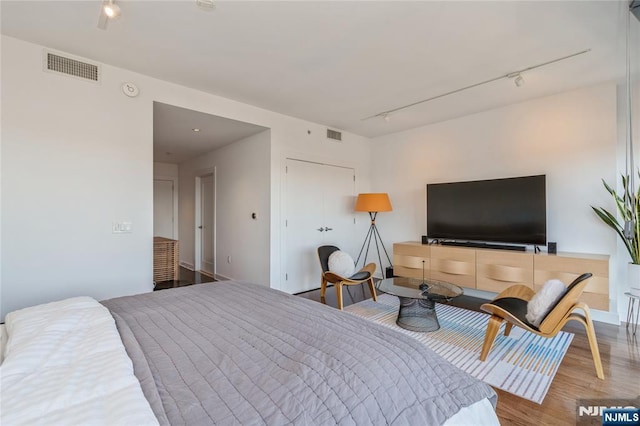 bedroom featuring track lighting and wood-type flooring