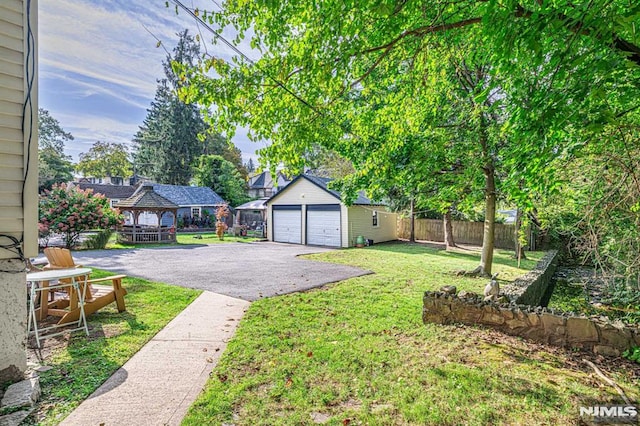 view of yard featuring an outbuilding, a garage, and a gazebo